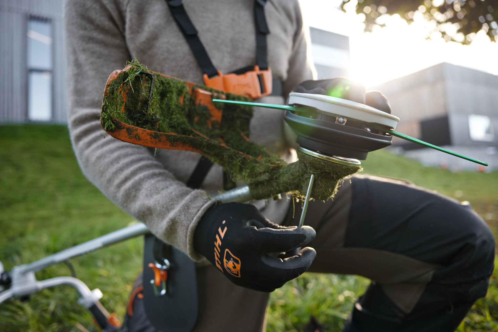 Person reinigt STIHL FSA 120 Akku-Motorsense im Freien