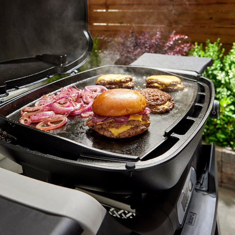 Grillplatte mit Burger und Zwiebeln auf Weber Q 2000N Serie Gasgrill im Garten