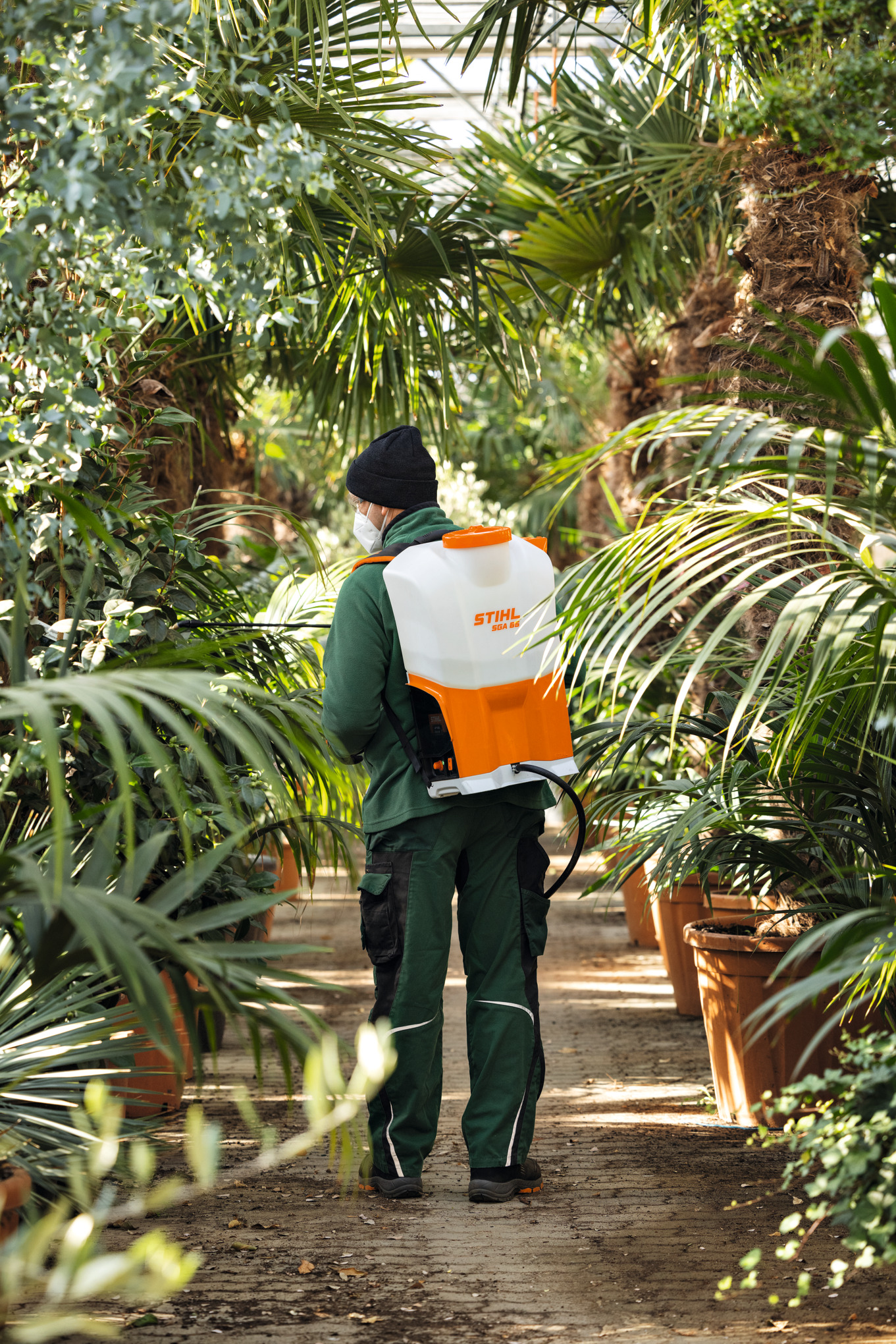 Person verwendet STIHL SGA 85 Spritzgerät im Gewächshaus