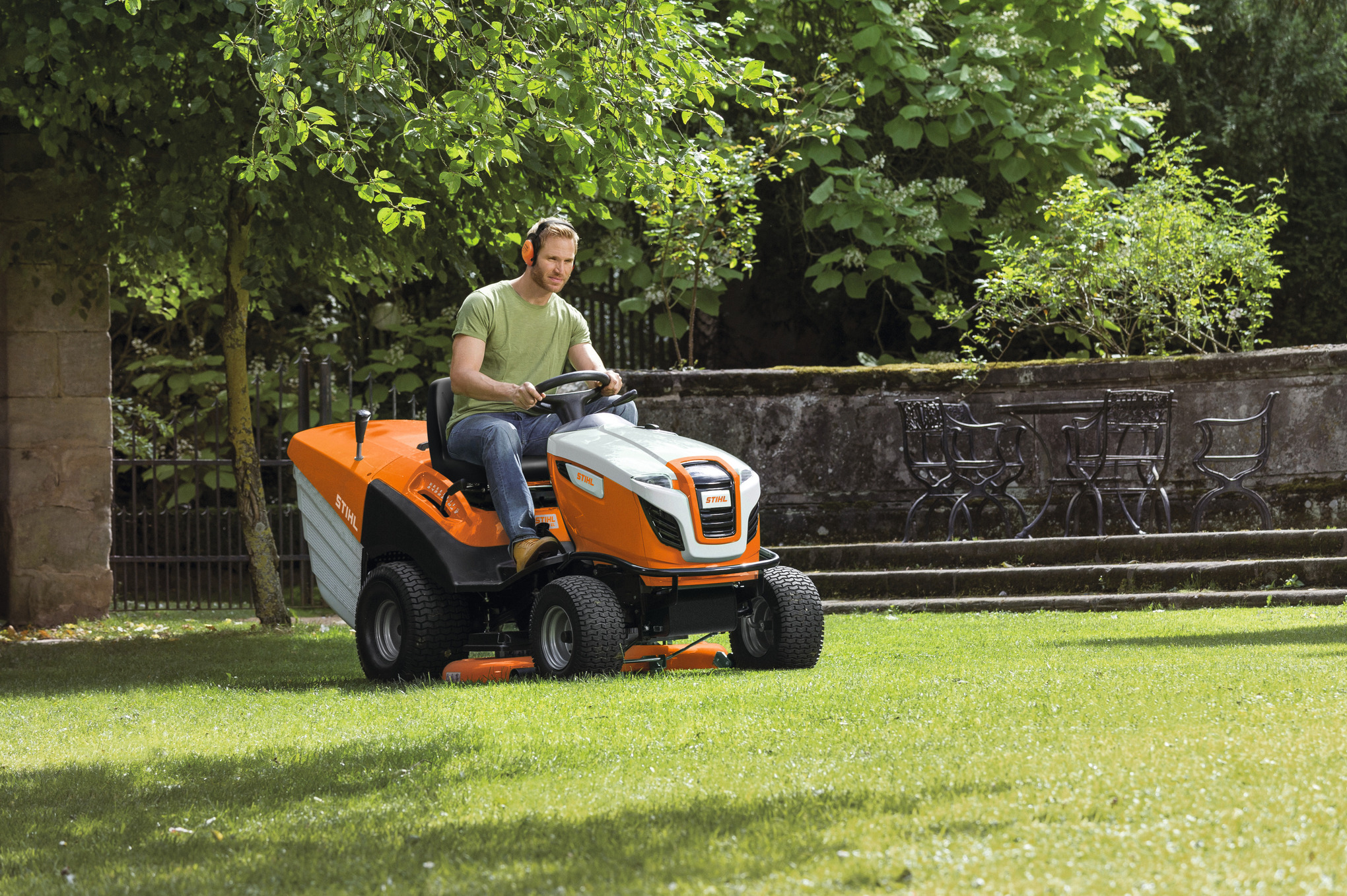 Mann benutzt STIHL RT 6127 ZL Aufsitzmäher in einem grünen Garten