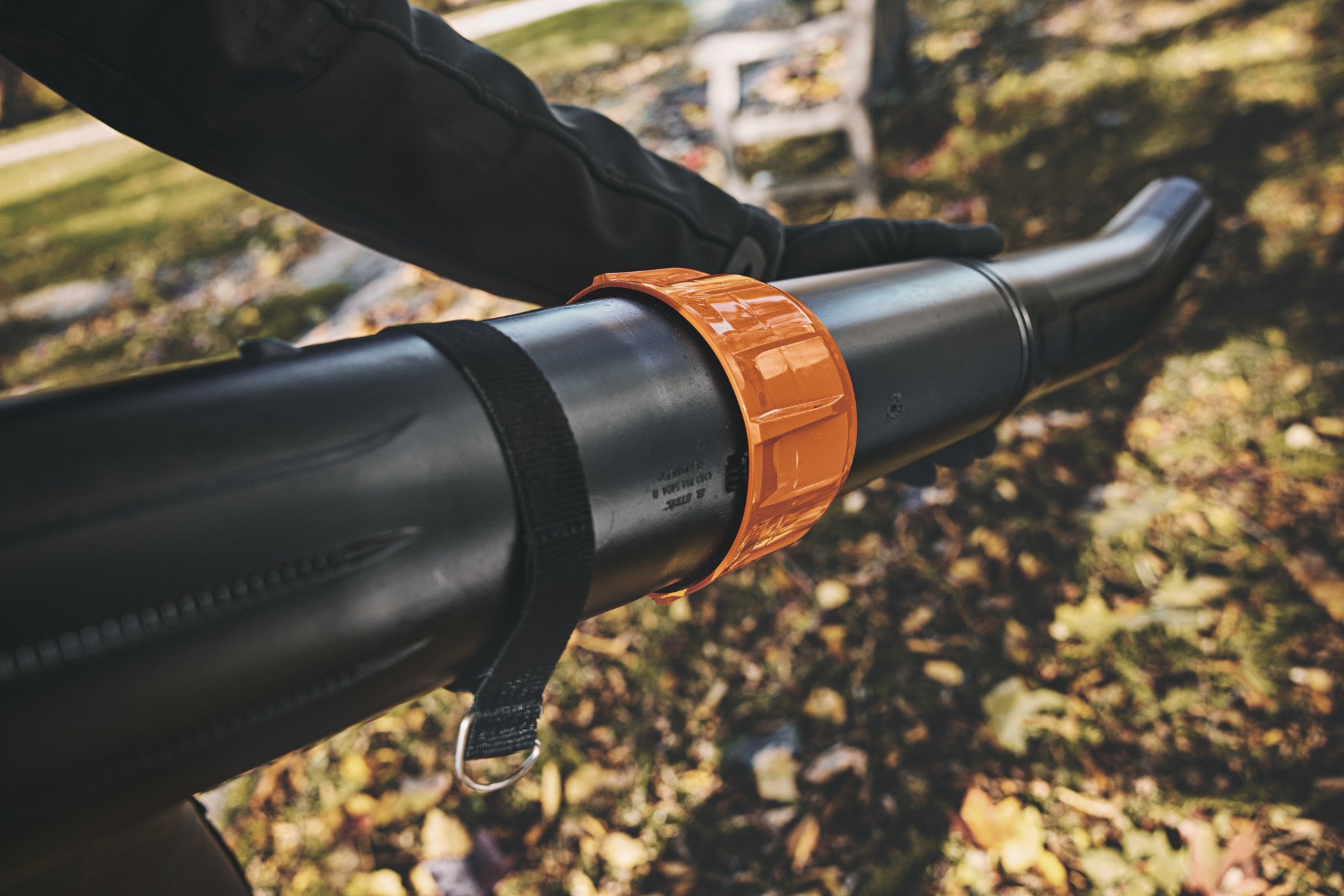 Nahaufnahme eines Stihl BGA 300 Laubbläsers mit Fokus auf Bediengriff und Blasrohr in herbstlicher Umgebung