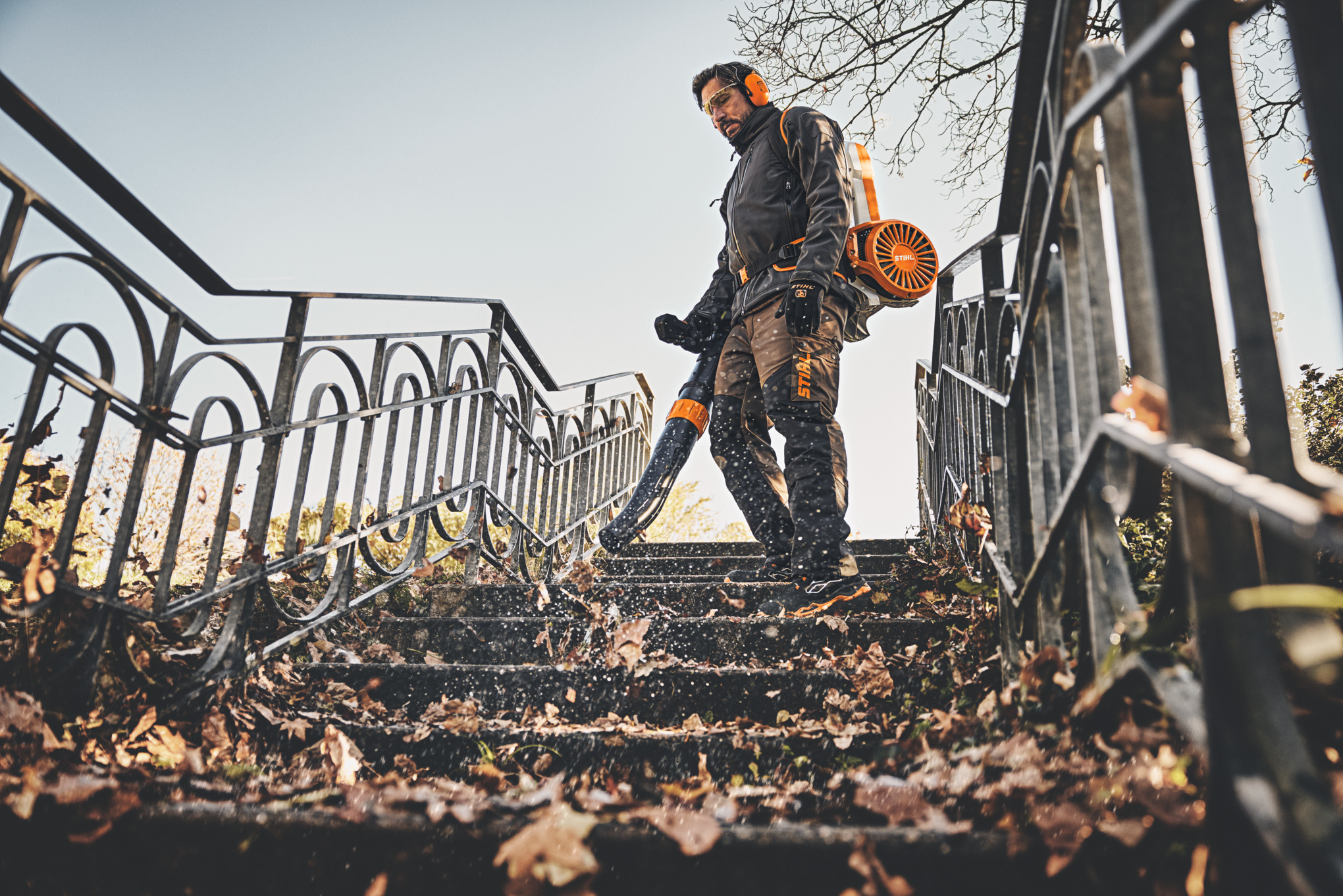 Mann verwendet Stihl BGA 300 Laubbläser auf herbstlicher Treppe