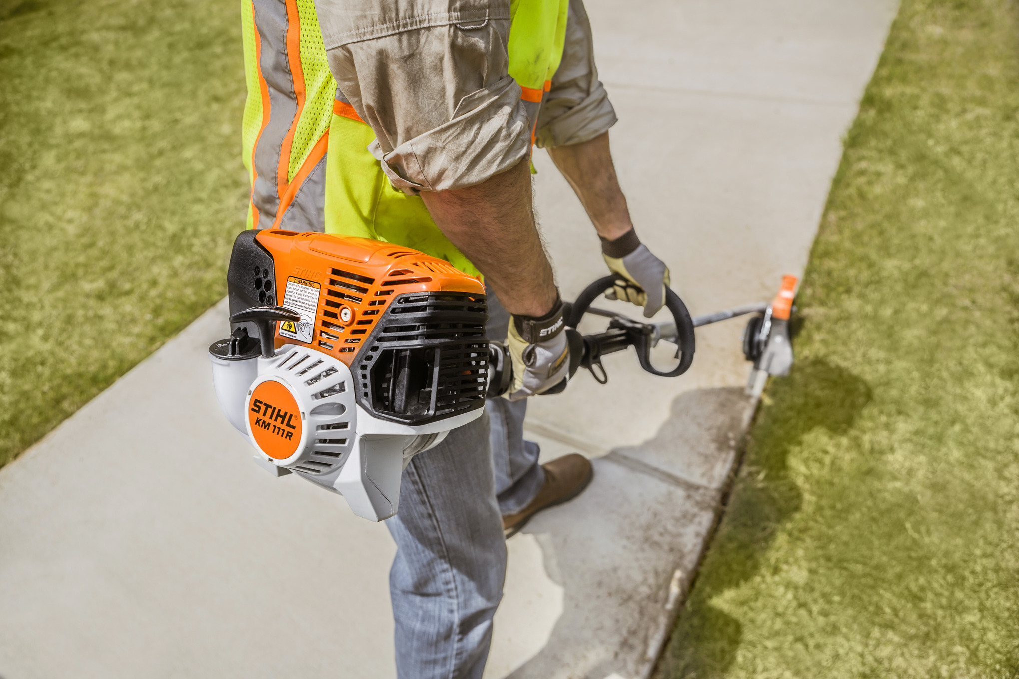 Professioneller Gärtner verwendet Stihl KM 111 R KombiMotor in einer Gartenanlage