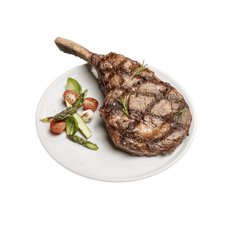 Weißer Weber Porzellan-Teller mit Steak und Gemüse auf grünem Hintergrund