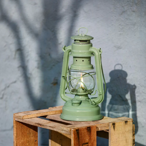 Verzinkte Sturmlaterne Feuerhand Baby Special 276 in Sage Green auf einem Holztisch