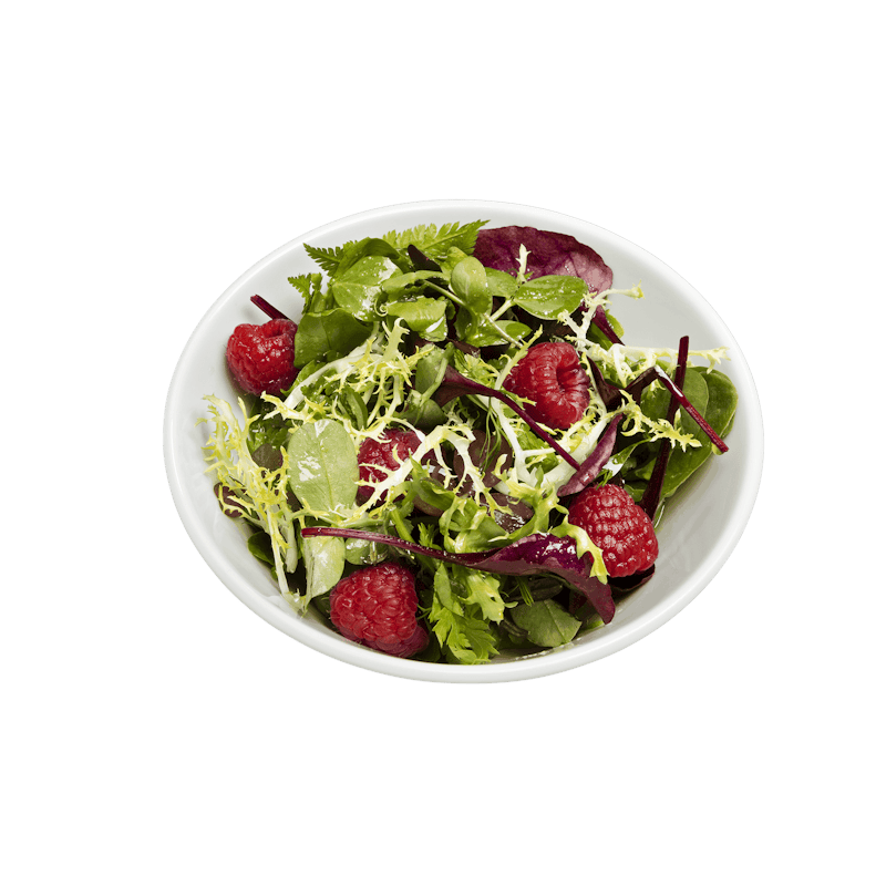 Weber Porzellanschüssel mit frischem Salat auf grünem Hintergrund
