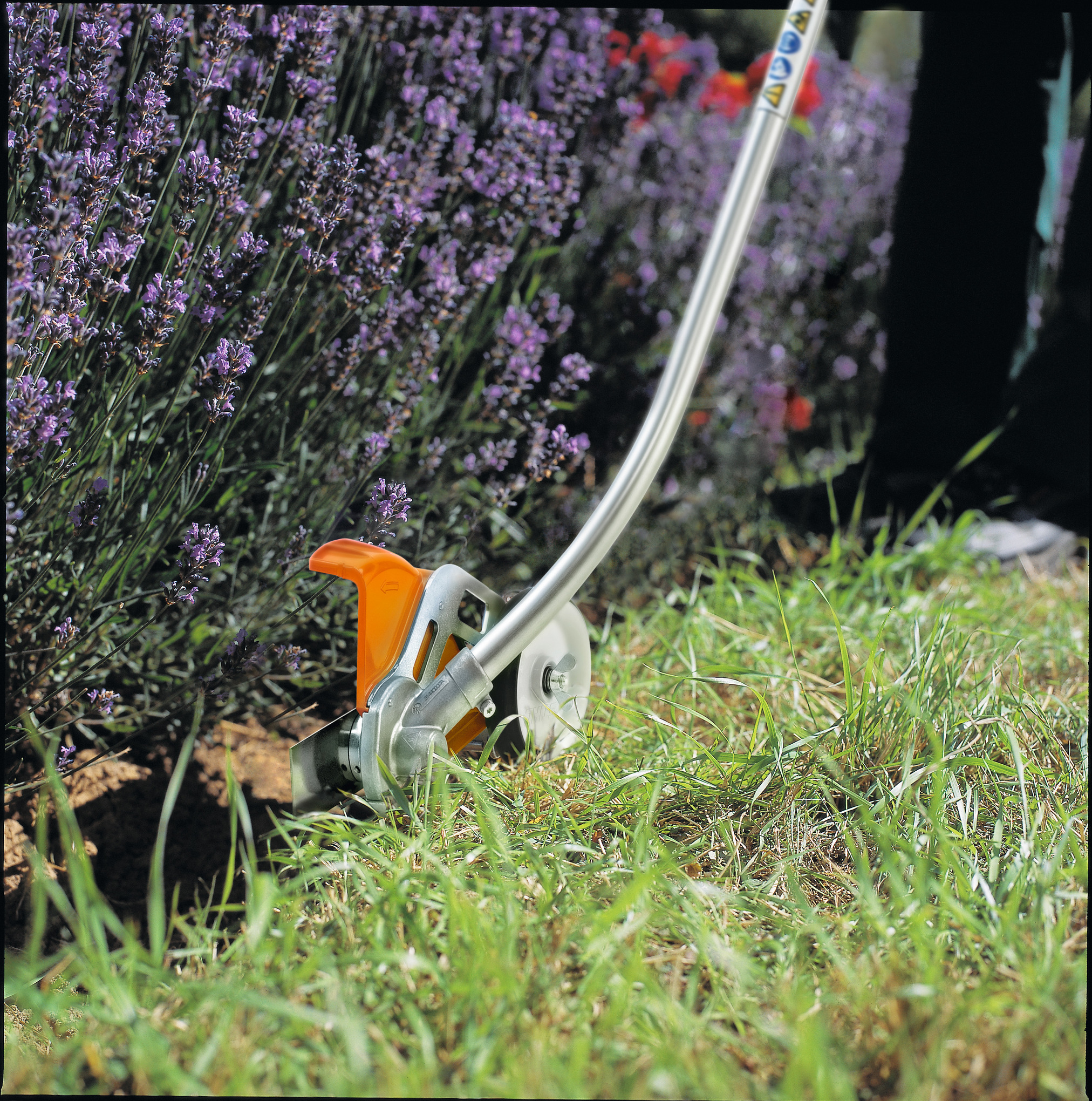 STIHL Kantenschneider im Einsatz bei der Pflege von Rasenkanten in einem blühenden Garten