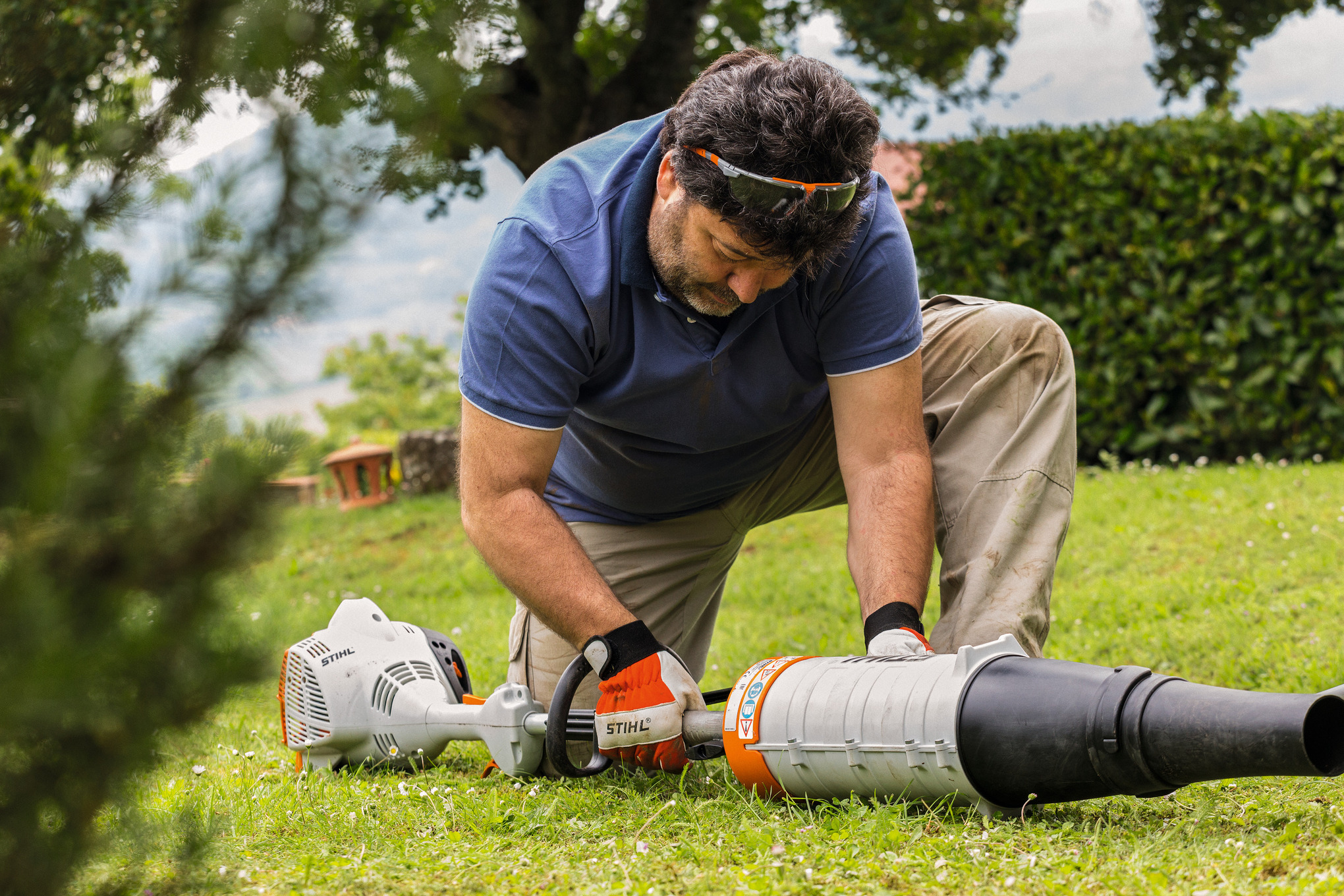 Mann mittleren Alters arbeitet an STIHL KombiMotor im Garten