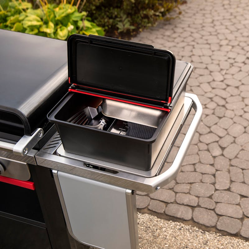 Weber Works Outdoor-Aufbewahrungsbox integriert in Weber Grill auf gepflastertem Außenbereich