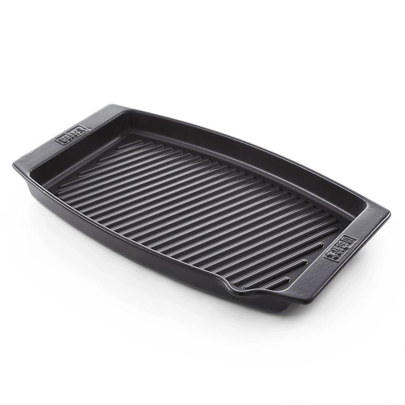 Schwarze Weber BBQ Keramik-Grillpfanne mit geriffeltem Boden auf dunkelgrünem Hintergrund