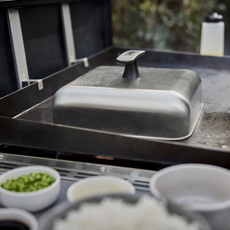 Weber Haube auf Grillplatte mit Zutaten im Freien