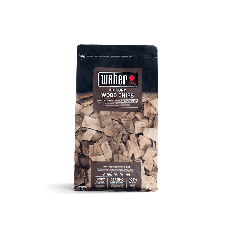 Verpackung von Weber Hickory Räucherchips 700g mit Holzchips im Hintergrund