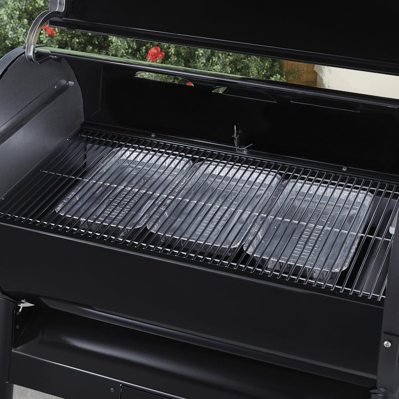 Schwarzer Weber Grill mit installiertem Wet-Smoke-Kit und leerem Rost im Freien