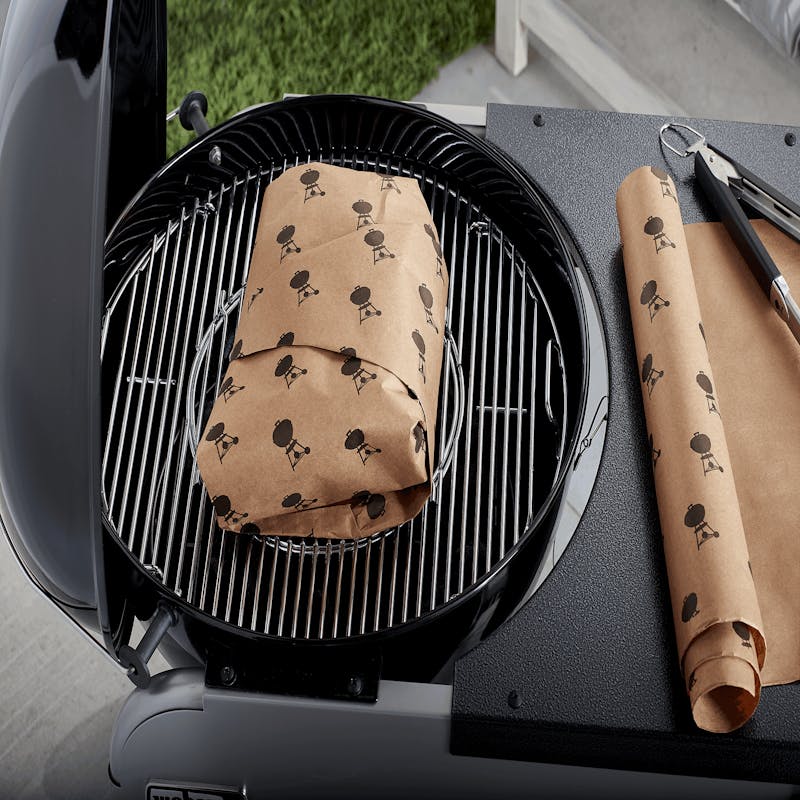 Weber Butcher Paper auf Grill mit Fleisch und zusätzlicher Rolle im Hintergrund