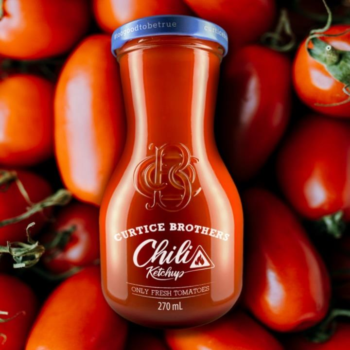 Curtice Brothers Bio Chili Ketchup Flasche umgeben von frischen Tomaten