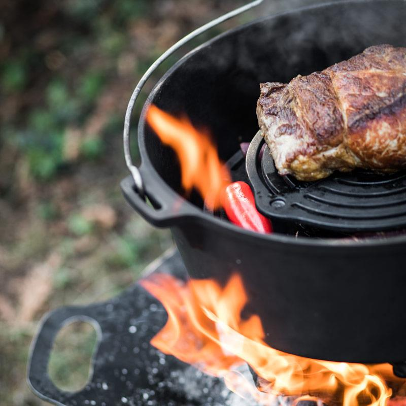 Petromax Gusseisen Stapelrost gr-s30 im Einsatz mit gebratenem Fleisch über offenem Feuer