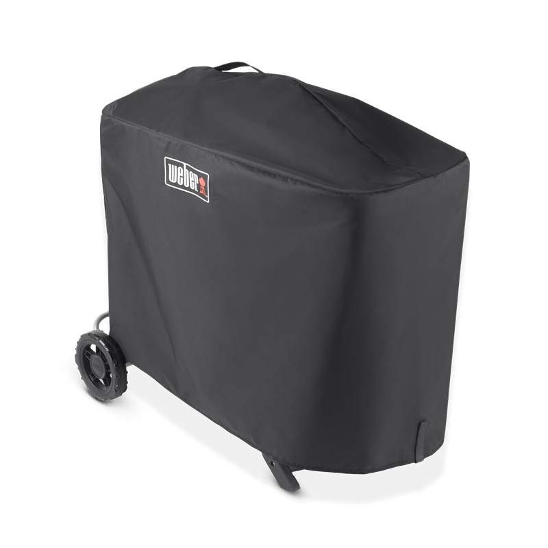 Weber Traveler Premium Abdeckhaube über einem Grill mit sichtbarem Weber-Logo