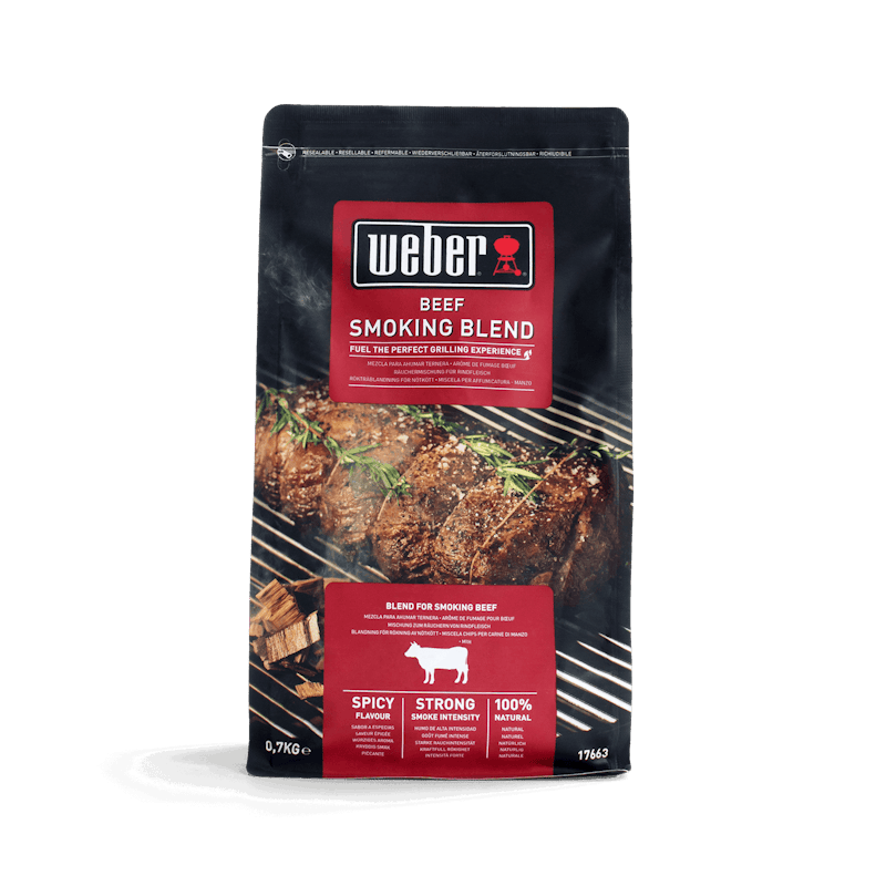 Weber Beef Smoking Blend Räucherchips Verpackung mit Grillfleisch im Hintergrund