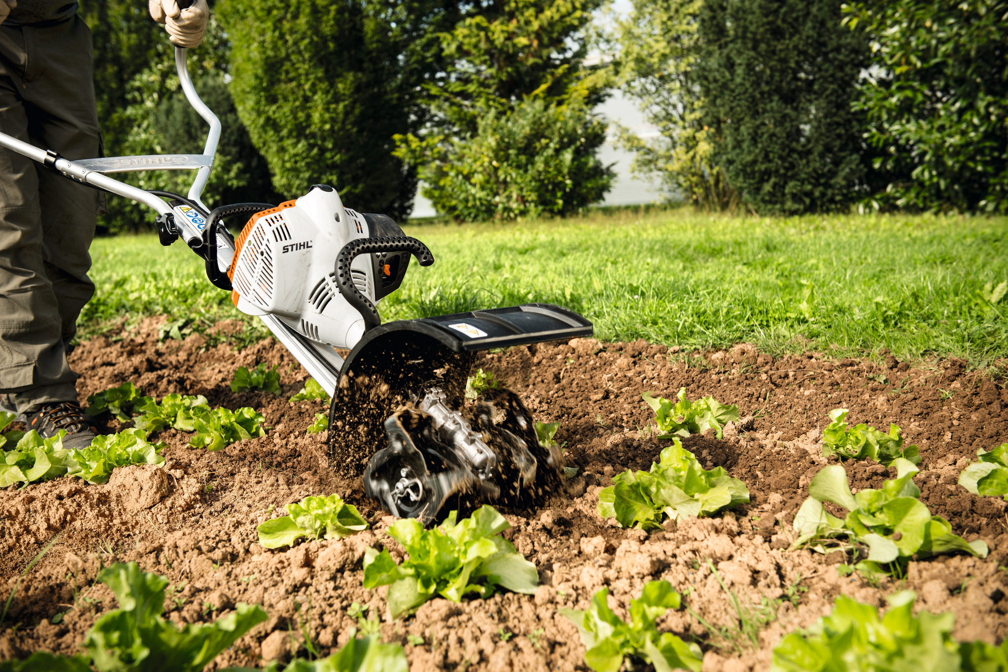 Person verwendet Stihl BK-MM Bodenkrümler im Garten zur Bodenbearbeitung