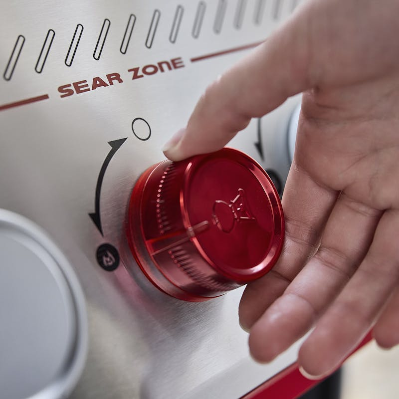 Hand bedient roten Drehknopf an Weber Gasgrill Sear Zone