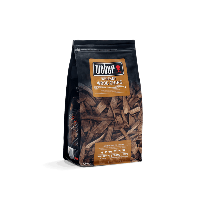 Packung Weber Räucherchips Whiskey 700g vor dunkelgrünem Hintergrund
