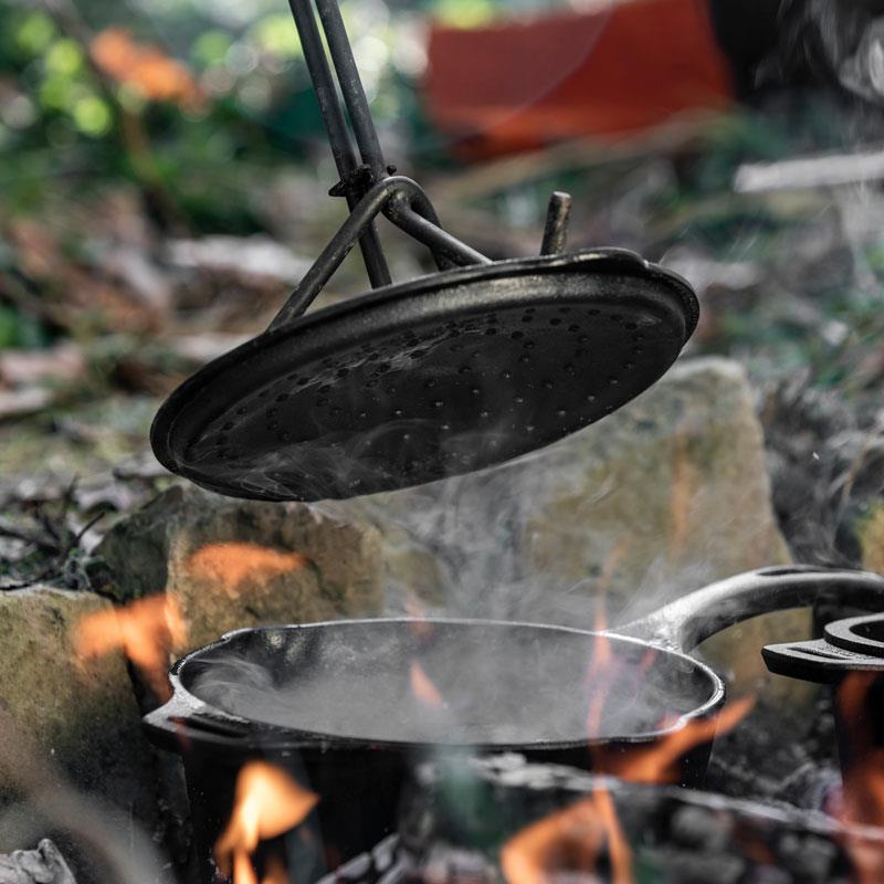 Gusseiserne Kasserolle über offenem Feuer in natürlicher Umgebung