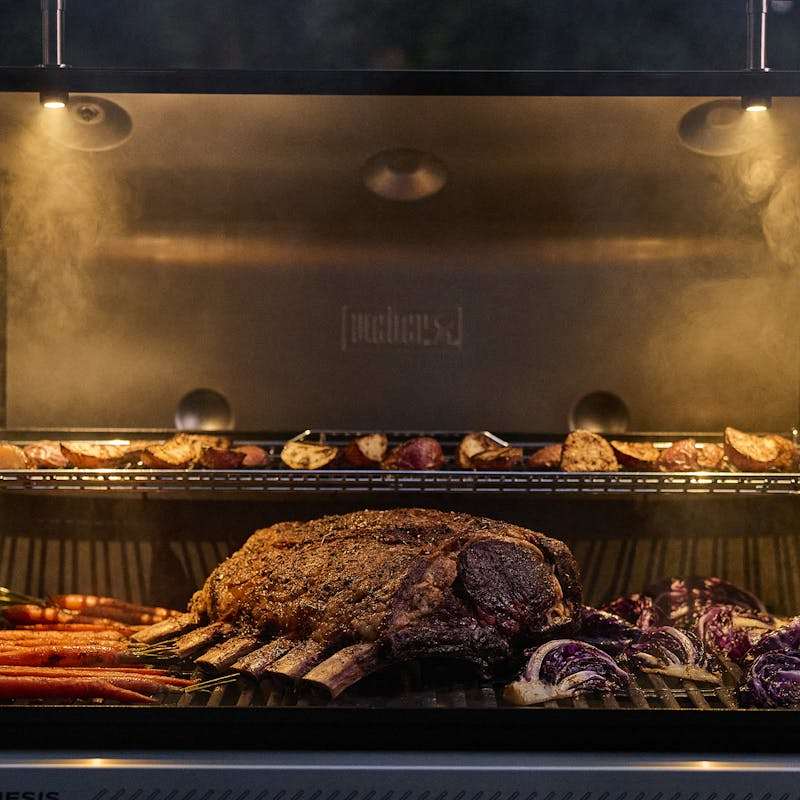 Weber GENESIS SP-335W GBS Gasgrill mit Fleisch und Gemüse bei Nacht