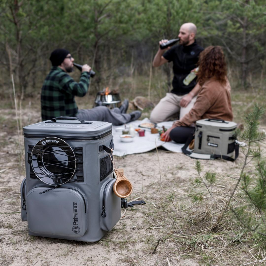 Drei Personen genießen eine Pause im Wald mit Petromax Kühlrucksack