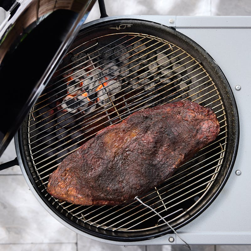 Weber Performer Premium Smart Holzkohlegrill mit gegrilltem Fleisch und glühenden Kohlen
