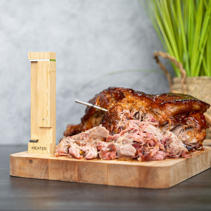 MEATER Pro Thermometer in Braten auf Holzbrett mit Logo und stilvoller Station