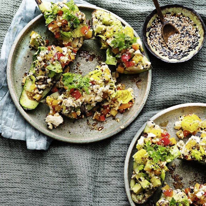 Gegrillte Avocado mit Tomaten und Körnern auf rustikalen Tellern
