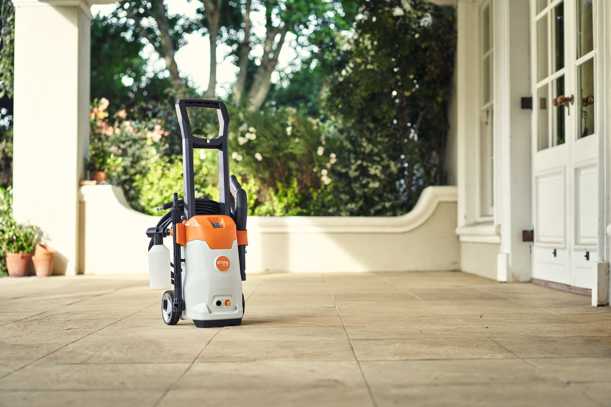 STIHL RE 80 Elektro-Hochdruckreiniger auf Terrasse vor Haus