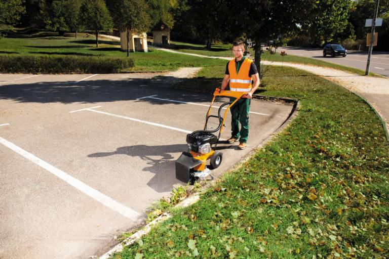 Mann verwendet AS 30 WeedHex 160 zur Unkrautentfernung auf einem Parkplatz