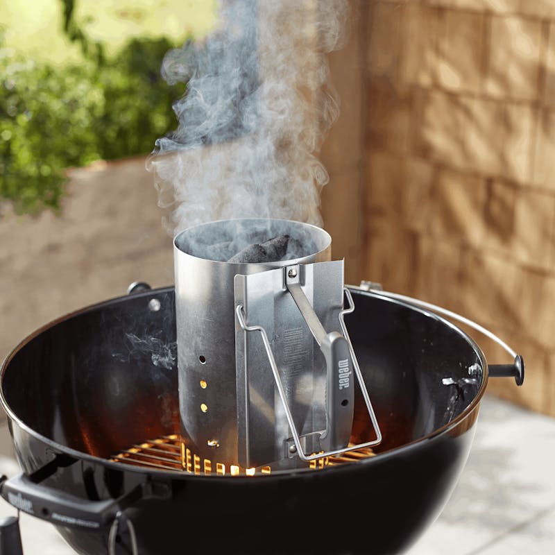 Weber Anzündkamin Rapidfire in Betrieb auf einem Grill mit aufsteigendem Rauch