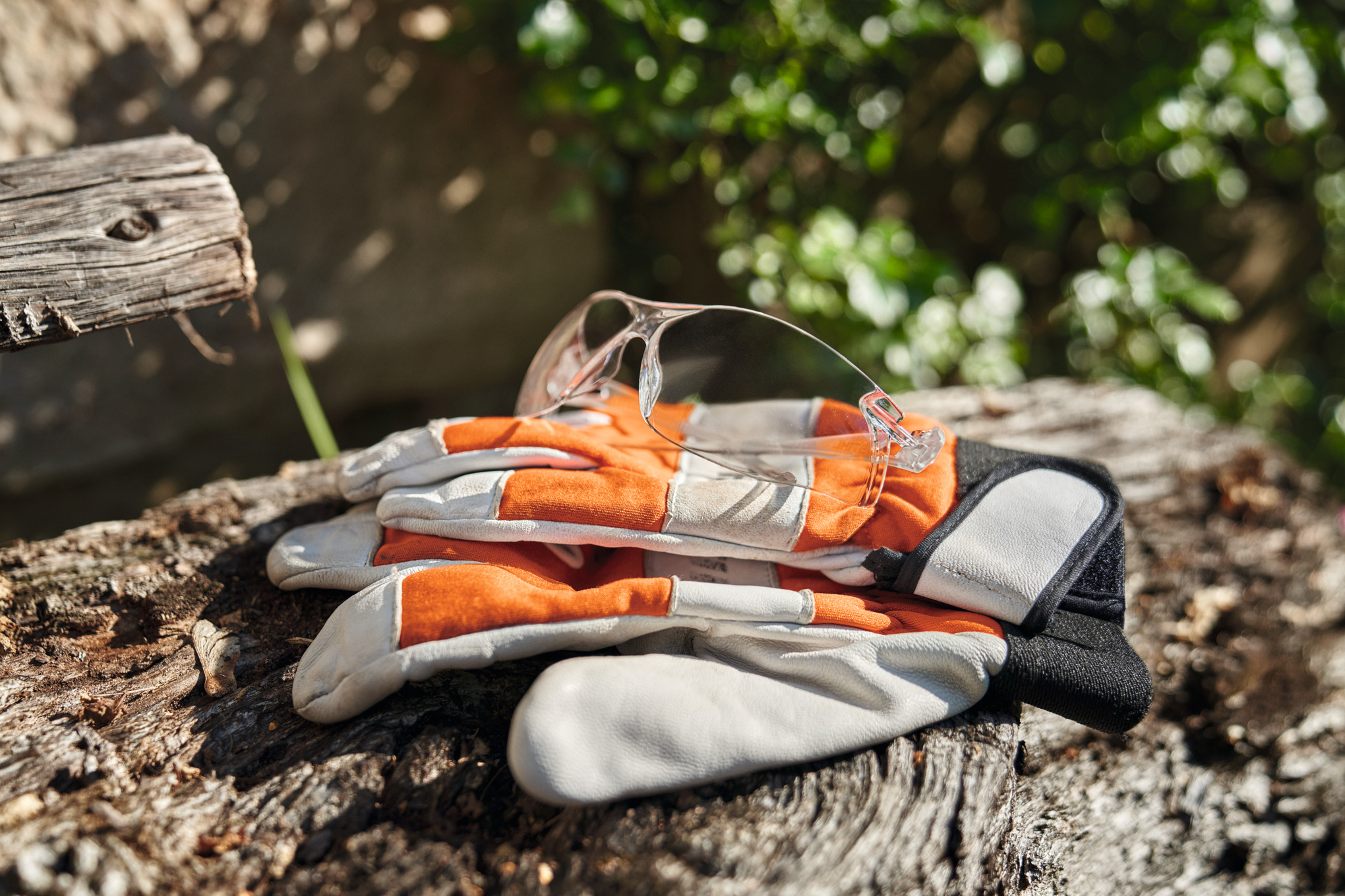 Transparente STIHL Schutzbrille auf Arbeitshandschuhen, natürliche Umgebung
