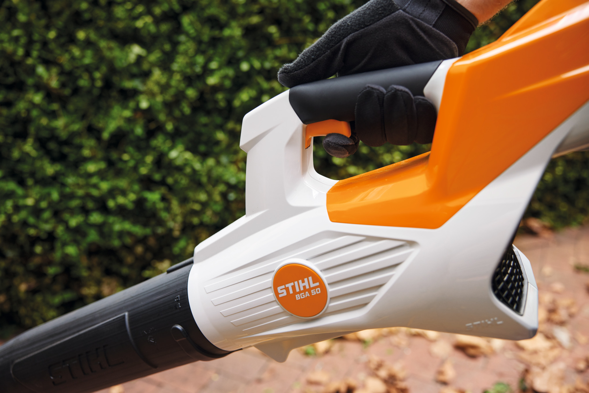 Person hält STIHL BGA 50 Akku-Laubbläser in Garten