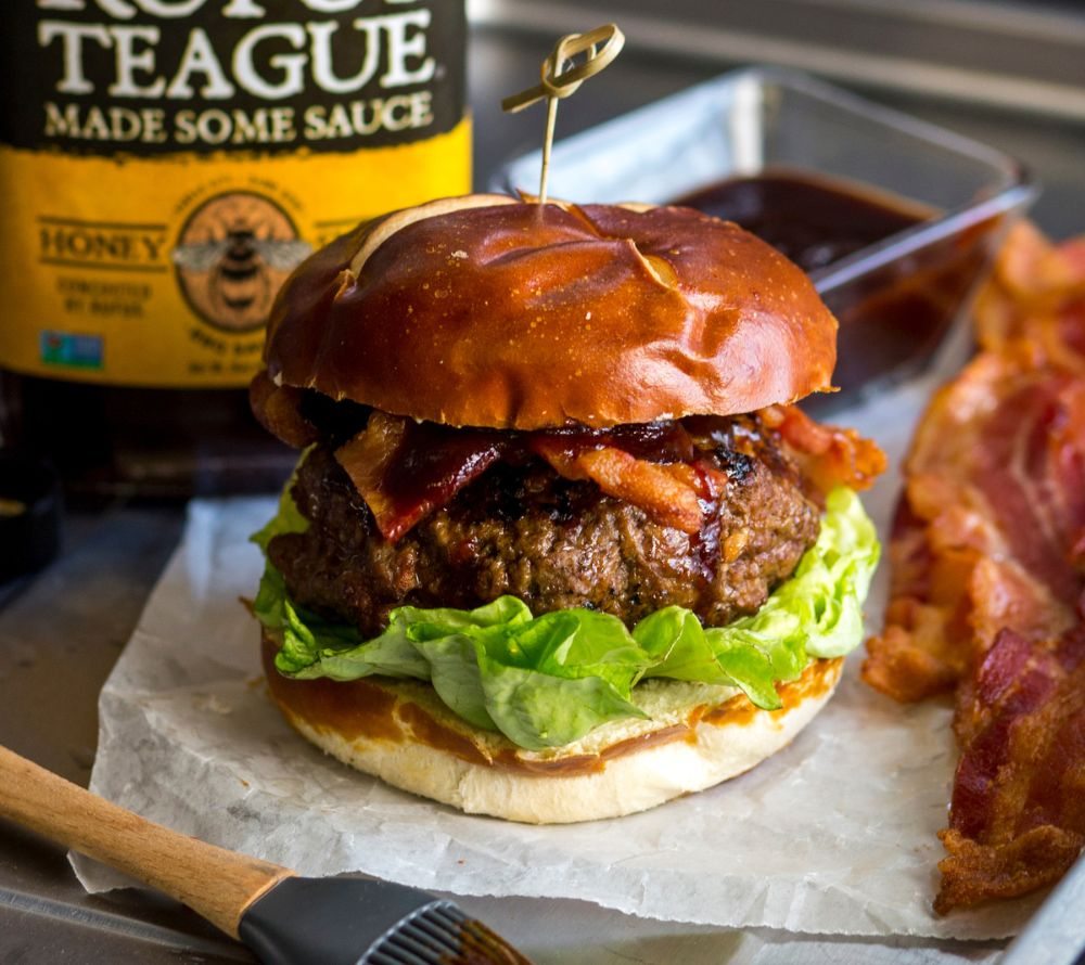 Burger mit Speck und Salat, Rufus Teague BBQ Sauce im Hintergrund