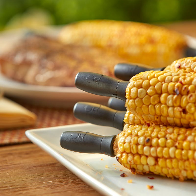 Gegrillte Maiskolben auf einem Teller mit Weber Maiskolbenhaltern