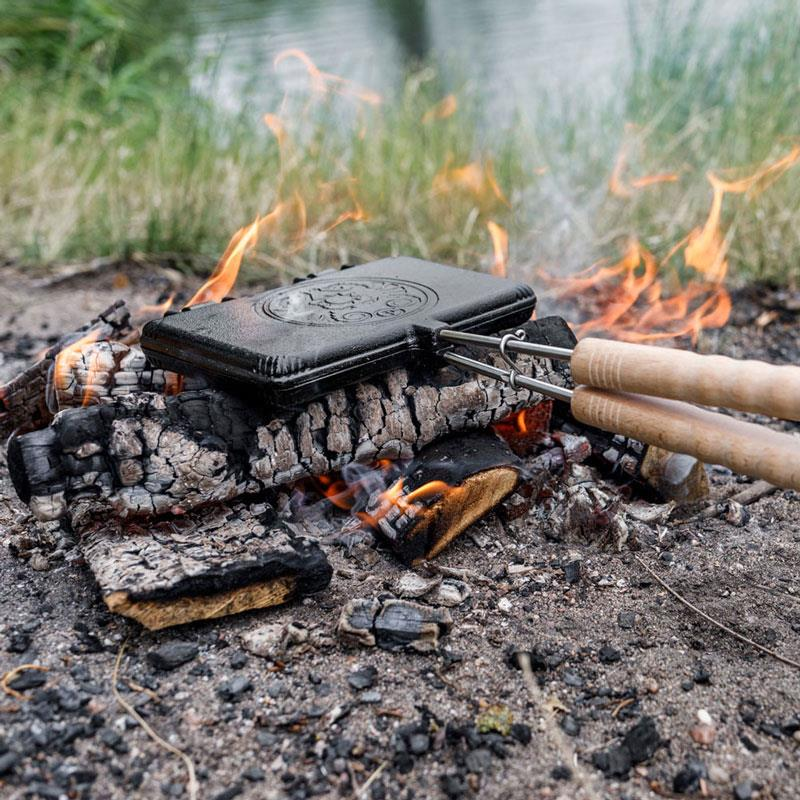 Petromax Waffeleisen über Lagerfeuer am Flussufer
