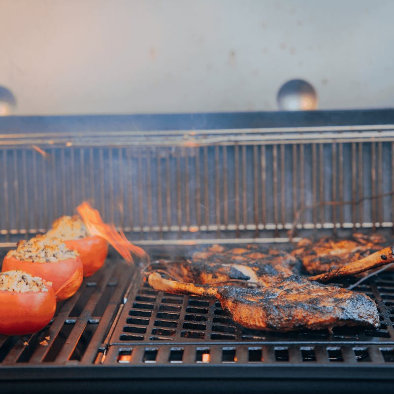 Steaks und gefüllte Paprikas auf Weber Sear Grate Grillrost mit sichtbaren Flammen