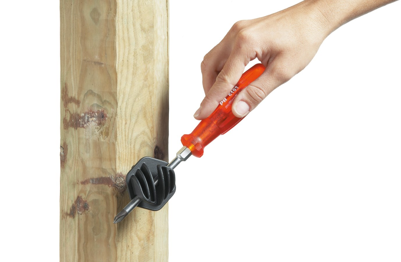 Hand montiert schwarzen Seilisolator mit orangefarbenem Schraubendreher an Holzpfosten