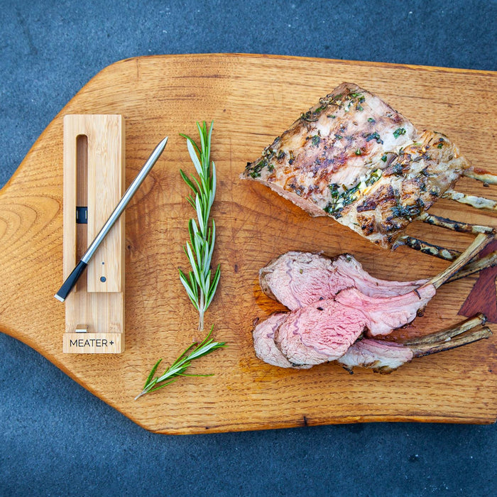 Gebratenes Fleisch auf Holzbrett mit MEATER Plus Thermometer und Rosmarin