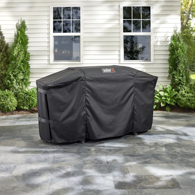 Weber Premium Abdeckhaube über einer Plancha auf einer Terrasse vor einem Haus