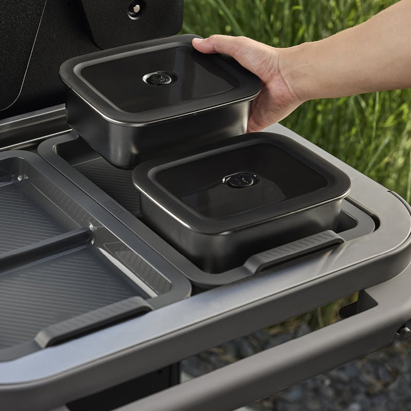 Person platziert Weber WORKS Edelstahl Aufbewahrungsbox auf Grilltisch