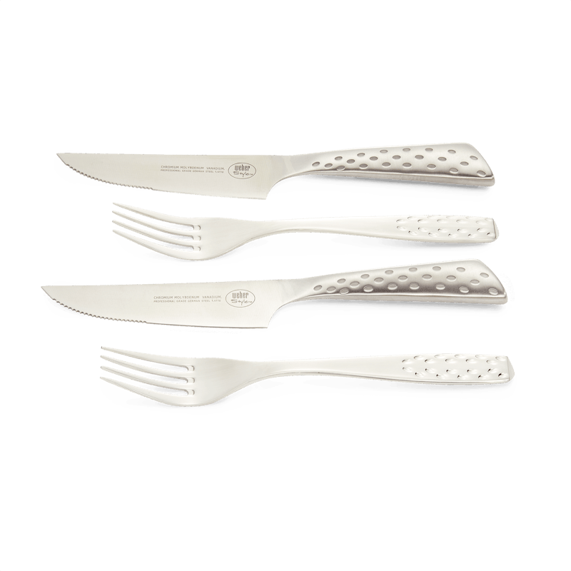 Weber Deluxe Steak-Set mit zwei Messern und zwei Gabeln auf grünem Hintergrund