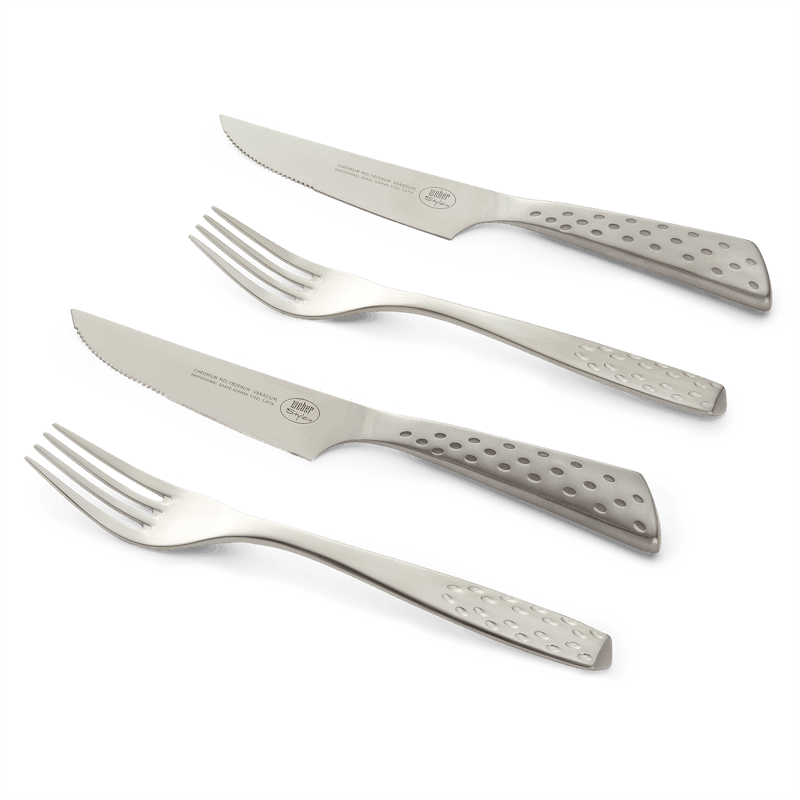 Weber Deluxe Steakbesteck-Set aus Edelstahl auf dunkelgrünem Hintergrund
