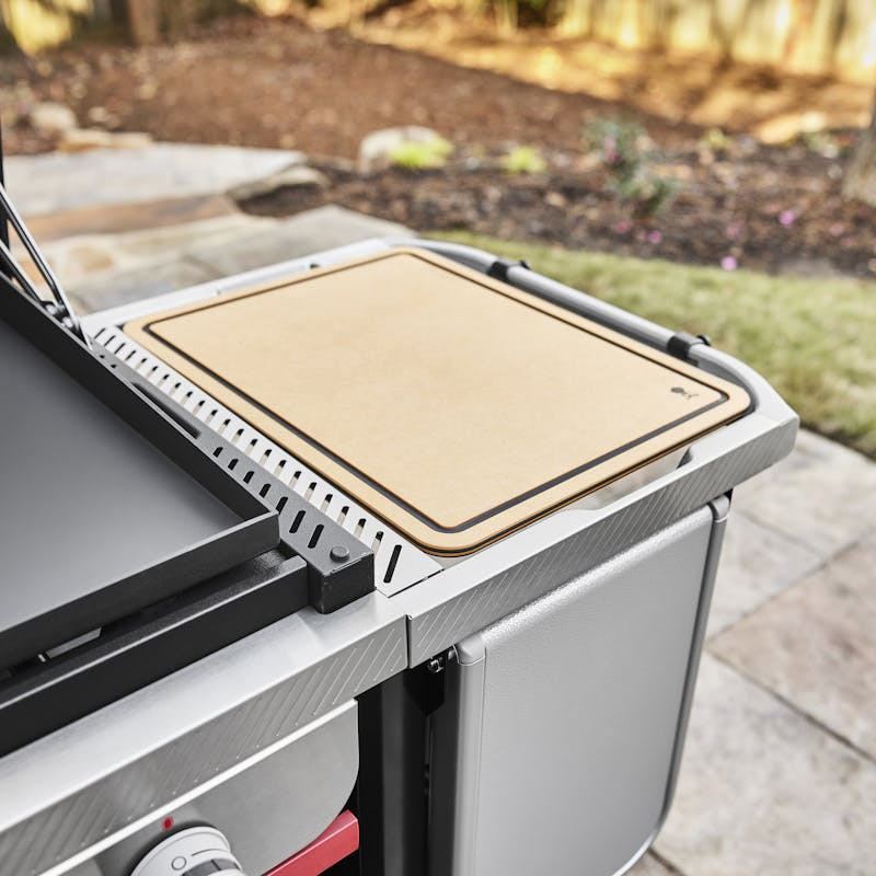 Weber Works Schneidebrett auf einem Grilltisch in einem Garten