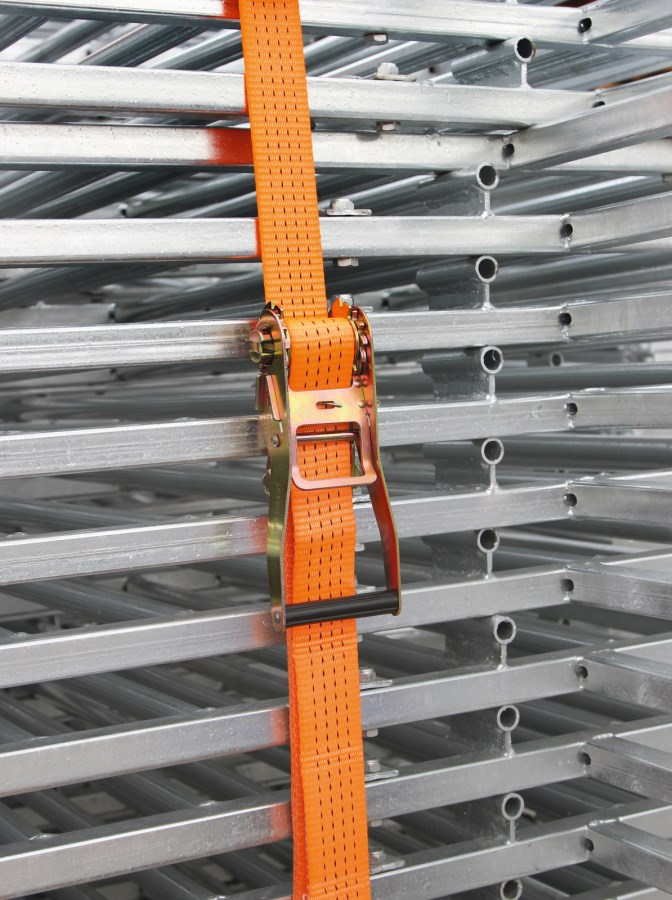 Orange Ratschenzurrgurt an verzinkten Stahlträgern befestigt