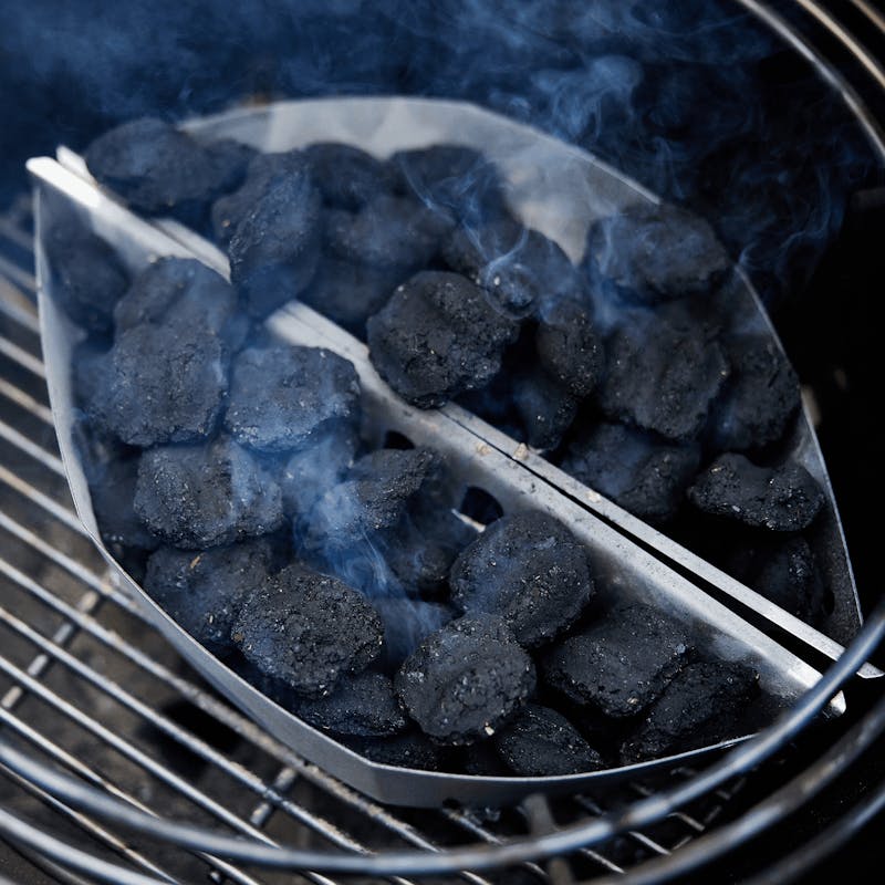 Weber Holzkohlekörbe Char-Basket auf Grillrost mit glühenden Kohlen und aufsteigendem Rauch