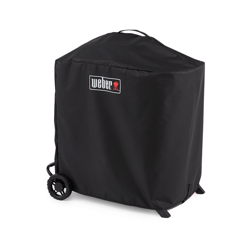 Schwarze Weber Premium Abdeckhaube über einem Gasgrill mit sichtbaren Rädern